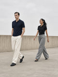 Two people in the Regular Fit Polo Shirt in Navy Blue and Black, walking apart on a raw concrete terrace in Los Angeles