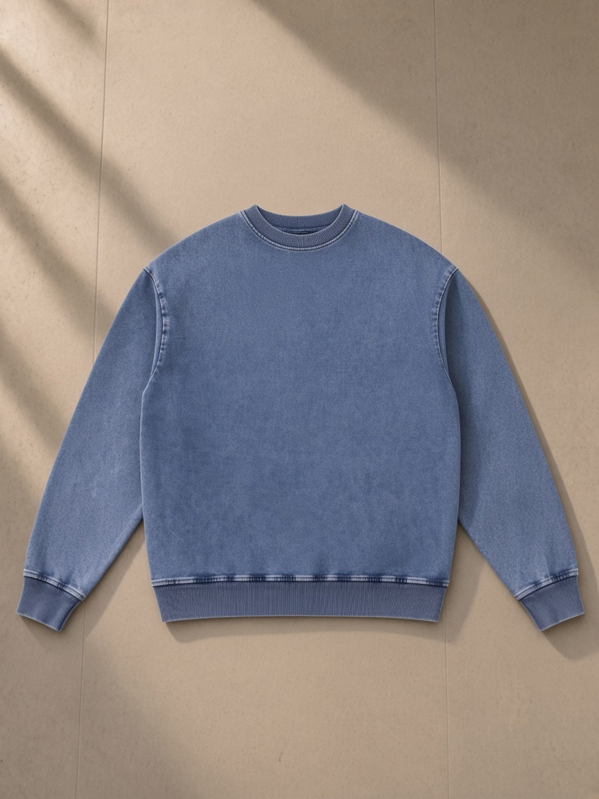Unisex snow wash oversized crewneck sweatshirt in Light Blue, laid flat on pale limestone, front view