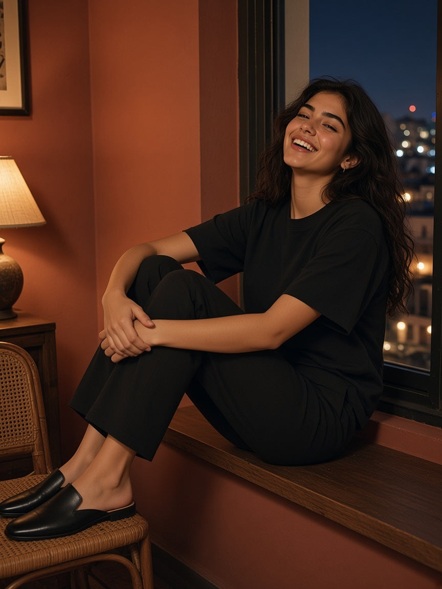 Woman in the Sorona Quick-Dry T-Shirt in Black on a hotel window seat in Mexico City at night