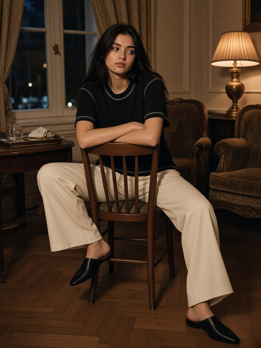 Woman in the Marcel Afters Sunfade Waffle Boxy T-Shirt in Black, in a Mayfair hotel lobby at night in London