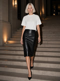 Woman in the Tonal Paneled Performance T-Shirt in White walking down a travertine palazzo stair in Milan at night