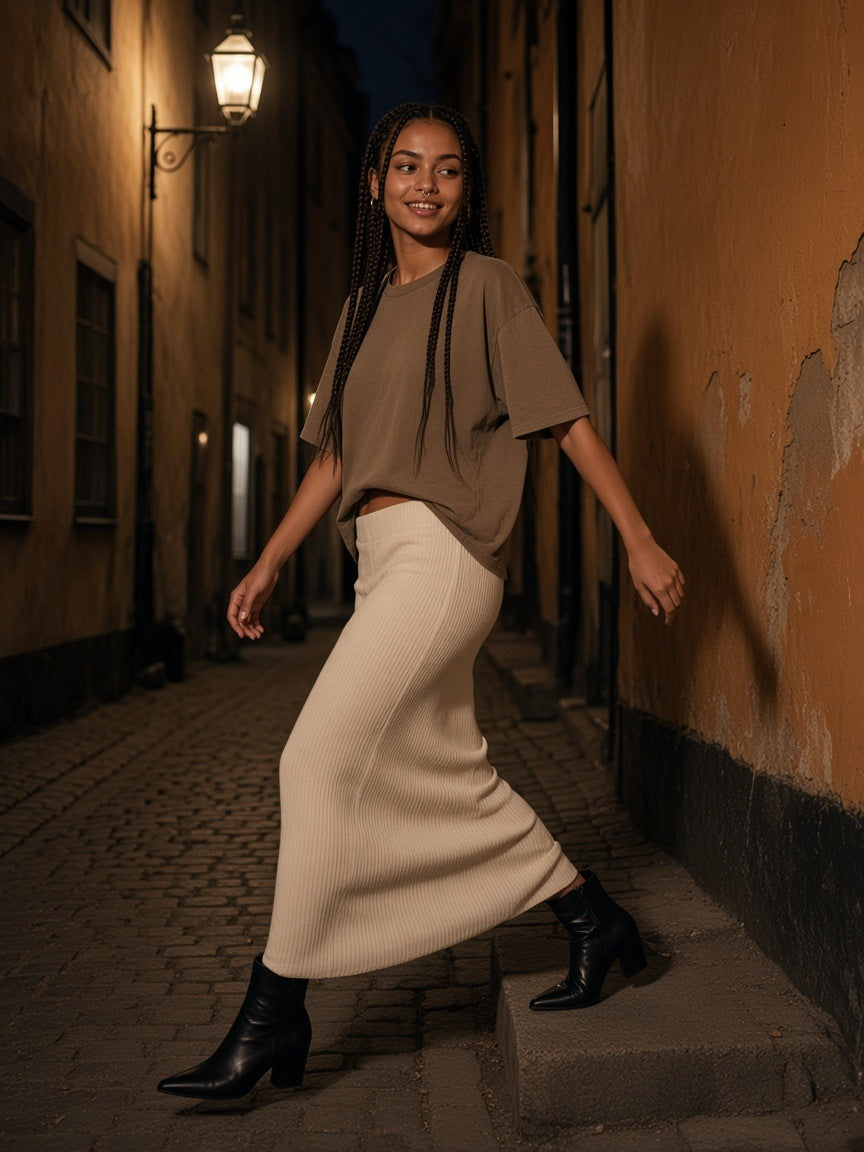 Woman in the Vintage Wash Boxy T-Shirt, 230 gsm in Brown and a knit maxi skirt in a Gamla Stan alley in Stockholm at night