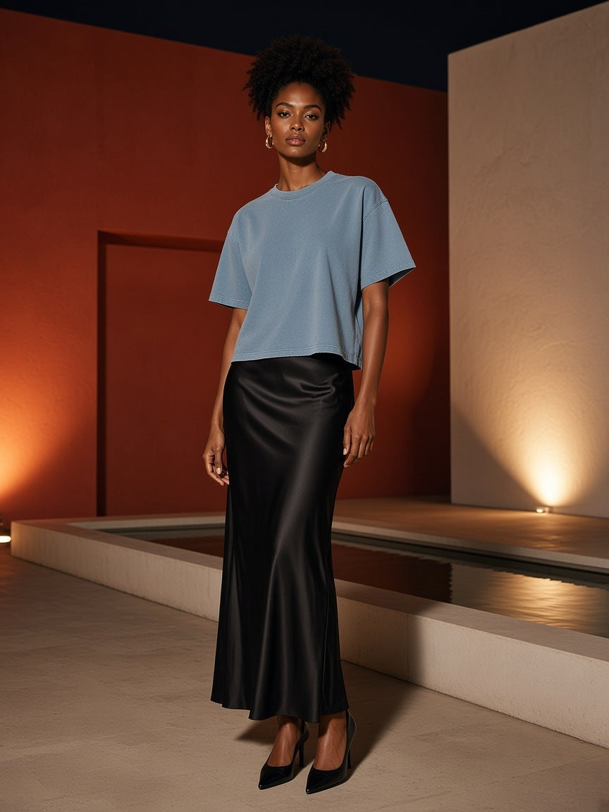 Woman in the Vintage Wash Boxy T-Shirt, 260 gsm, in Blue, in a modernist hotel courtyard at night in Mexico City