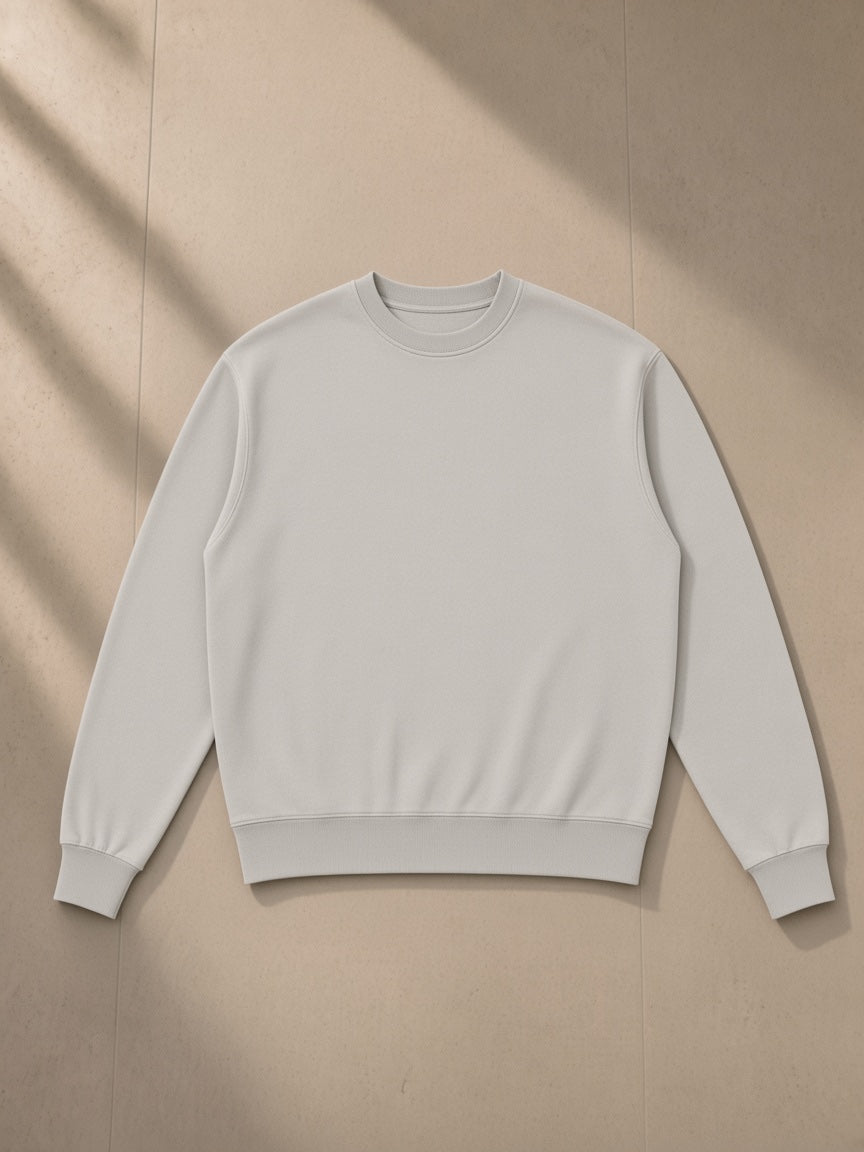 Unisex vintage wash crewneck sweatshirt in Light Gray, laid flat on pale limestone, front view