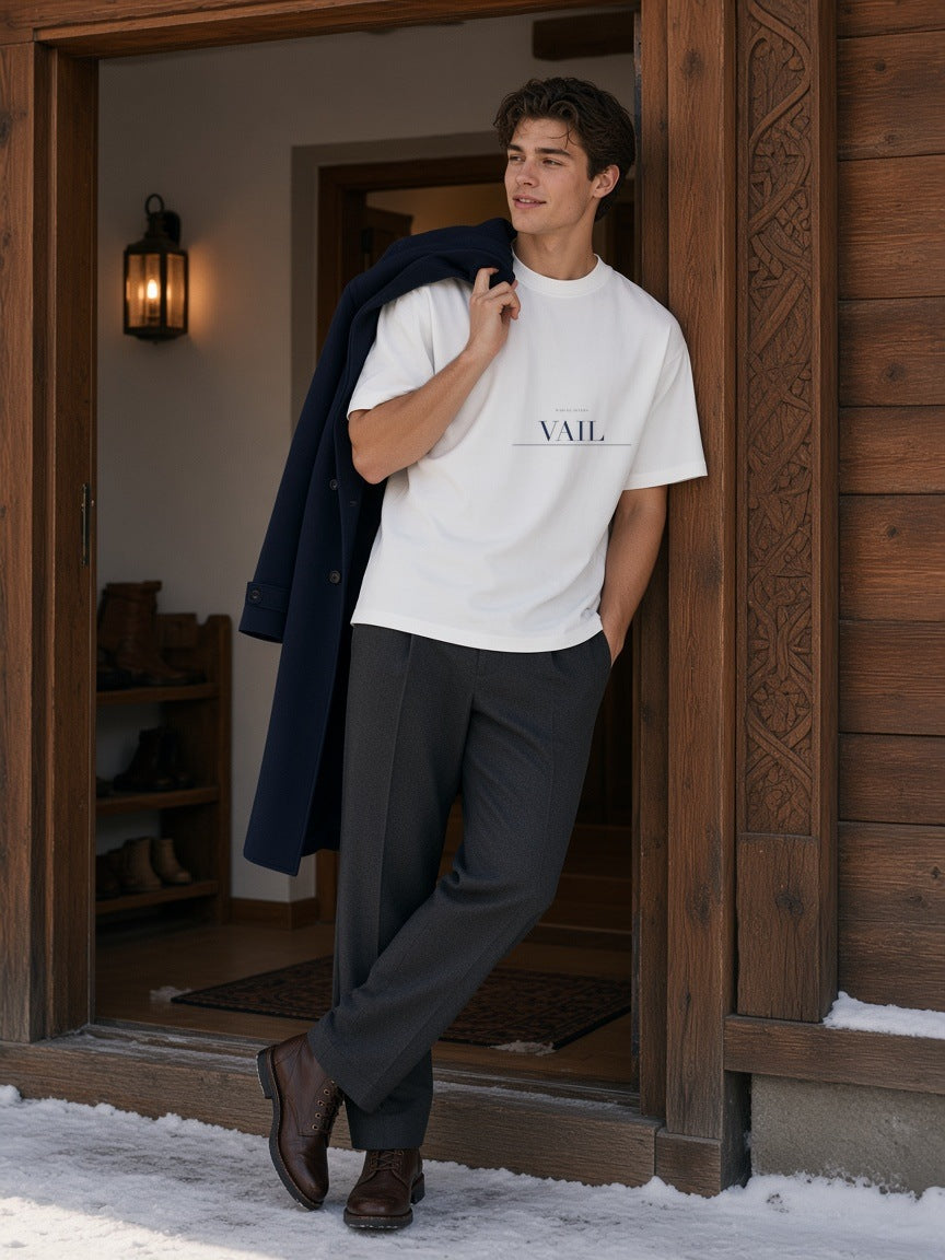 Man in the Vail Heavyweight Drop Shoulder T-Shirt in White by a steaming lodge pool in Vail in the morning
