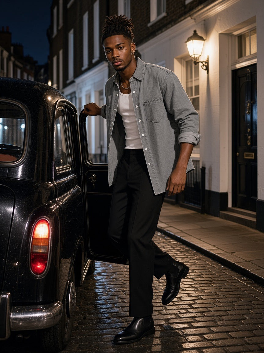 Man in the Vintage Wash Denim Shirt in Light Gray, worn open over a white tank, stepping out of a black cab in a London mews at night
