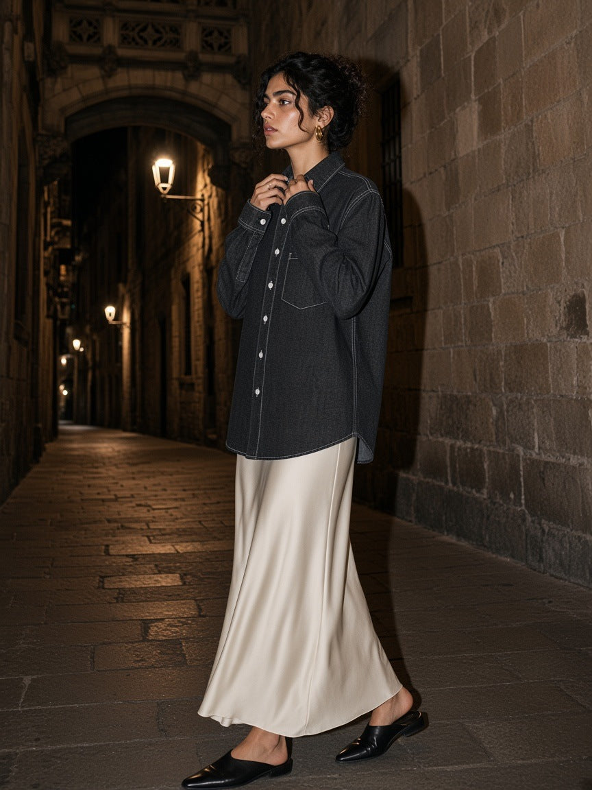 Woman in the Marcel Afters Vintage Wash Denim Shirt in Black in a stone lane in the Gothic Quarter, Barcelona at night