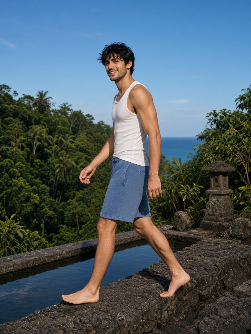 Man in the Vintage Wash Fleece Shorts in Washed Blue at a cliff-top pool at a resort in Bali in the morning