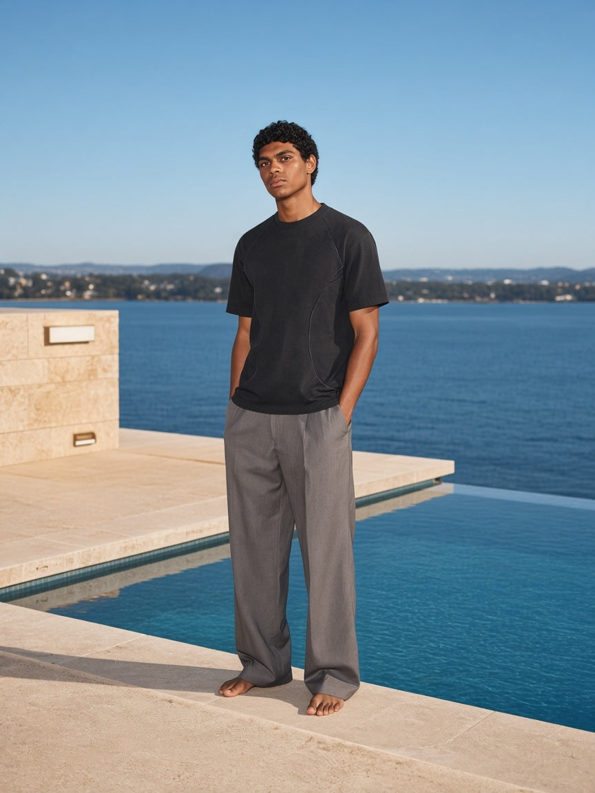 Man in the Vintage Wash Paneling T-Shirt in Black at a rooftop pool at a hotel in Sydney in the morning