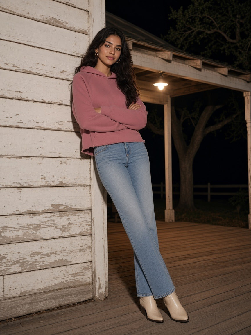 Woman in the Vintage Wash Raw Edge Boxy Hoodie in Carmine and light jeans on a farmhouse porch at night