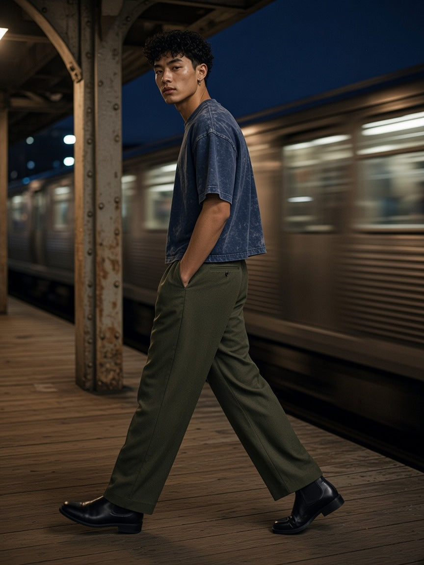 Man in the Vintage Wash Sunfade Boxy T-Shirt in Navy Blue walking along an elevated train platform in Chicago at night