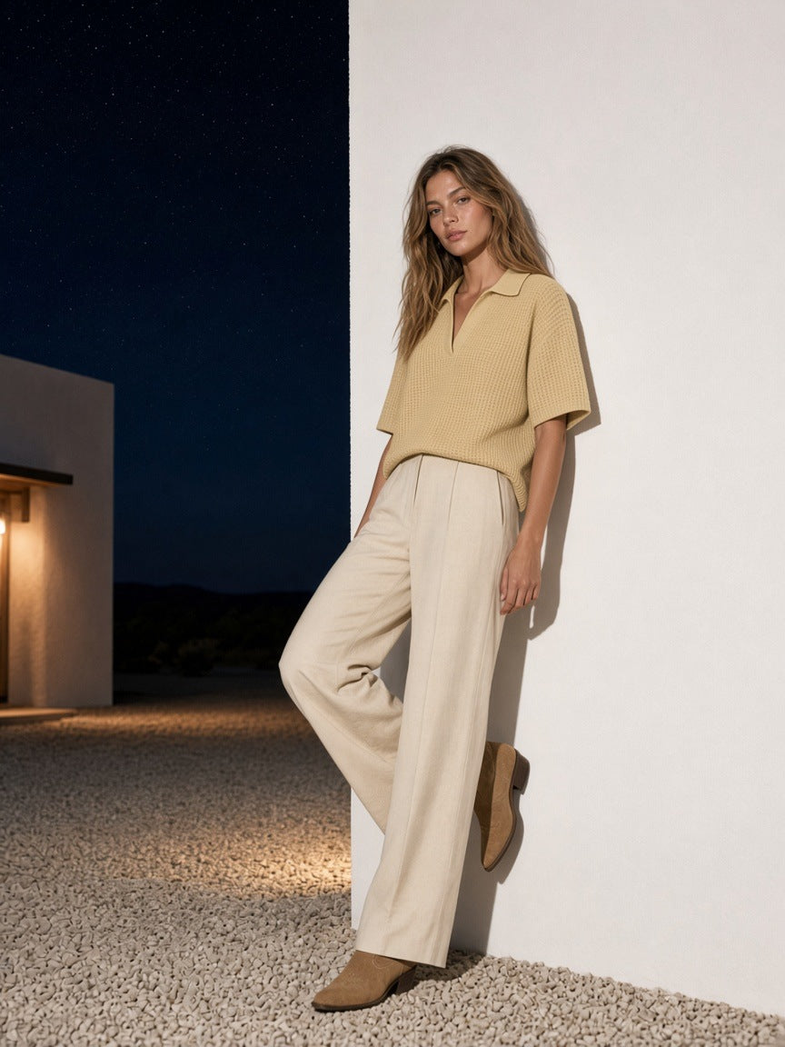 Woman in the Vintage Wash Waffle Boxy Polo Shirt in Khaki against a desert house wall in Marfa at night