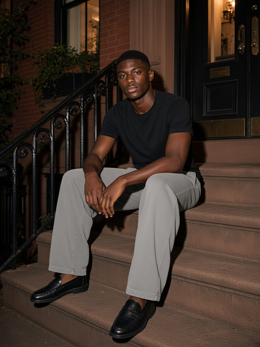 Man in the Vintage Washed Barrel Leg Sweatpants in Light Gray sitting on a brownstone stoop in the West Village, New York at night