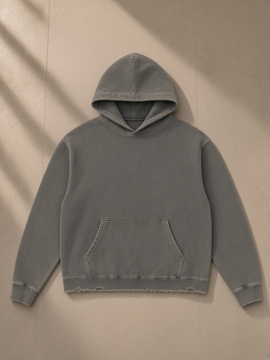 Vintage washed frayed-hem hoodie in Gray, laid flat on pale limestone, front view