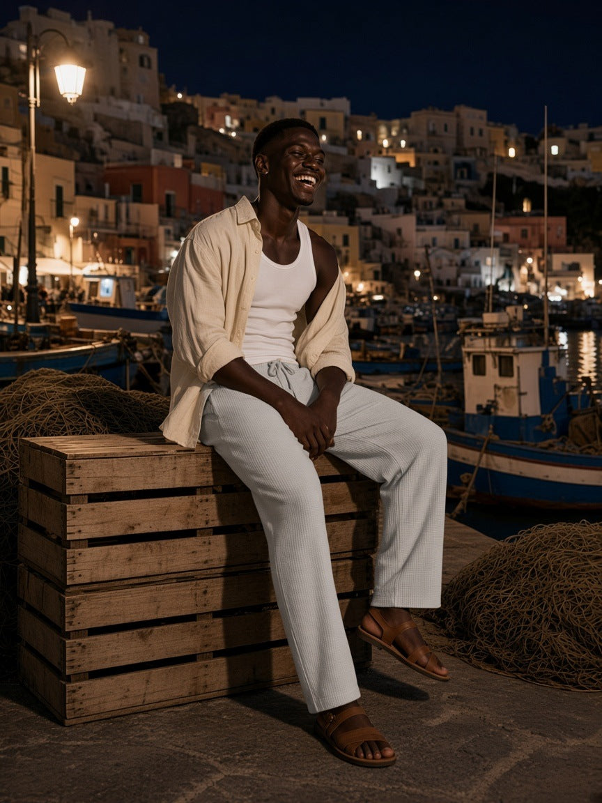 Man in the Waffle Barrel Leg Pants in Oat Gray with an open linen shirt and fisherman sand