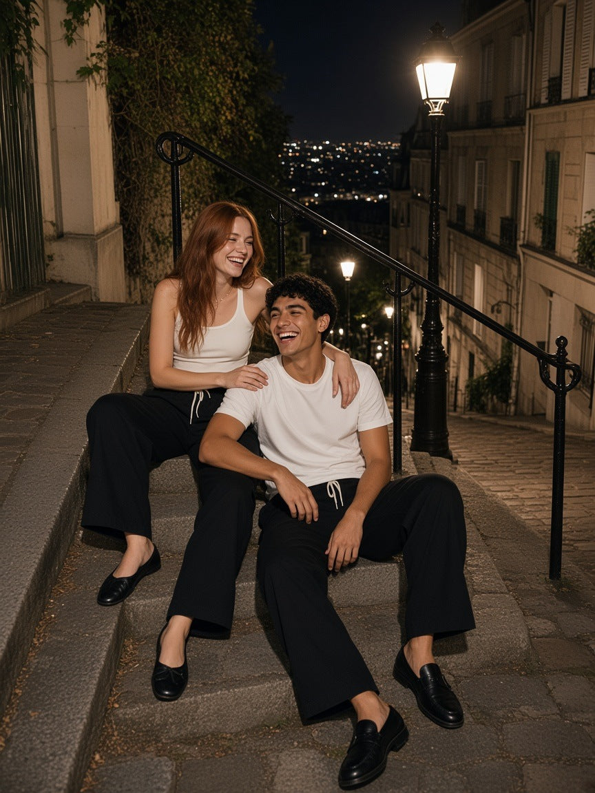 Two people in the Marcel Afters Wide Leg Drawstring Pants in Black on the Montmartre steps in Paris at night