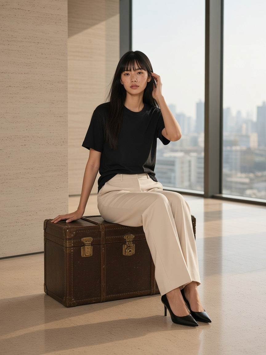 Woman in the Women's Essential Heavyweight Cotton T-Shirt in Black walking through a travertine hotel lobby in Shanghai by day