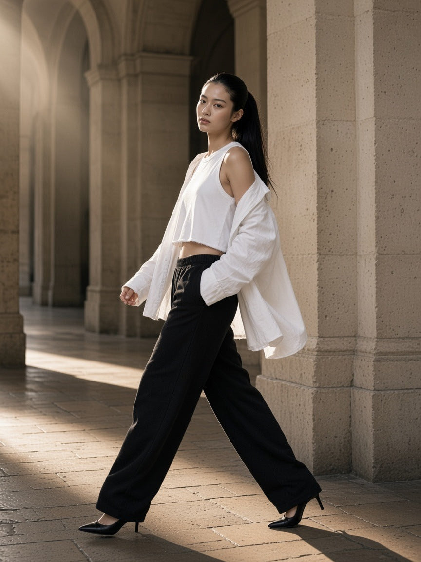 Woman in the Women's French Terry Boxy Tank Top in White leaning under limestone arcades in Paris by day