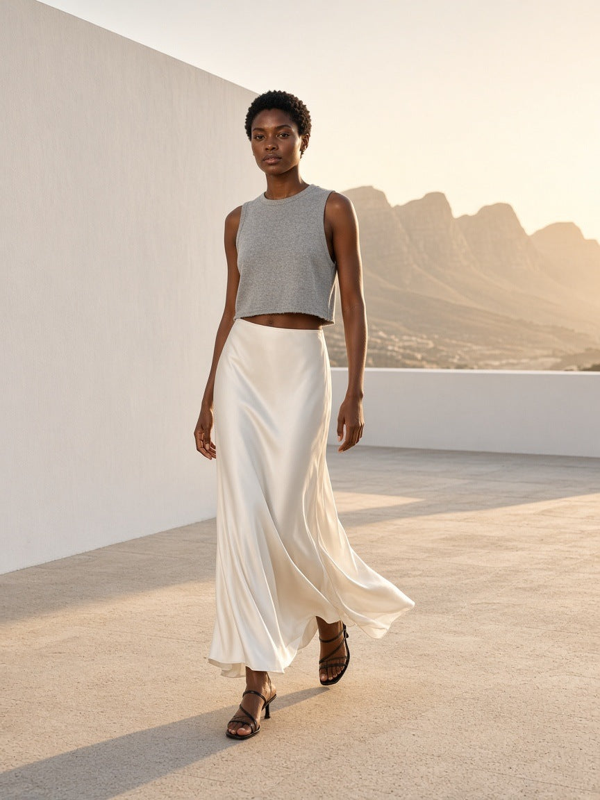 Woman in the Women's French Terry Boxy Tank Top in Gray with an ivory satin maxi skirt, walking a sunlit terrace