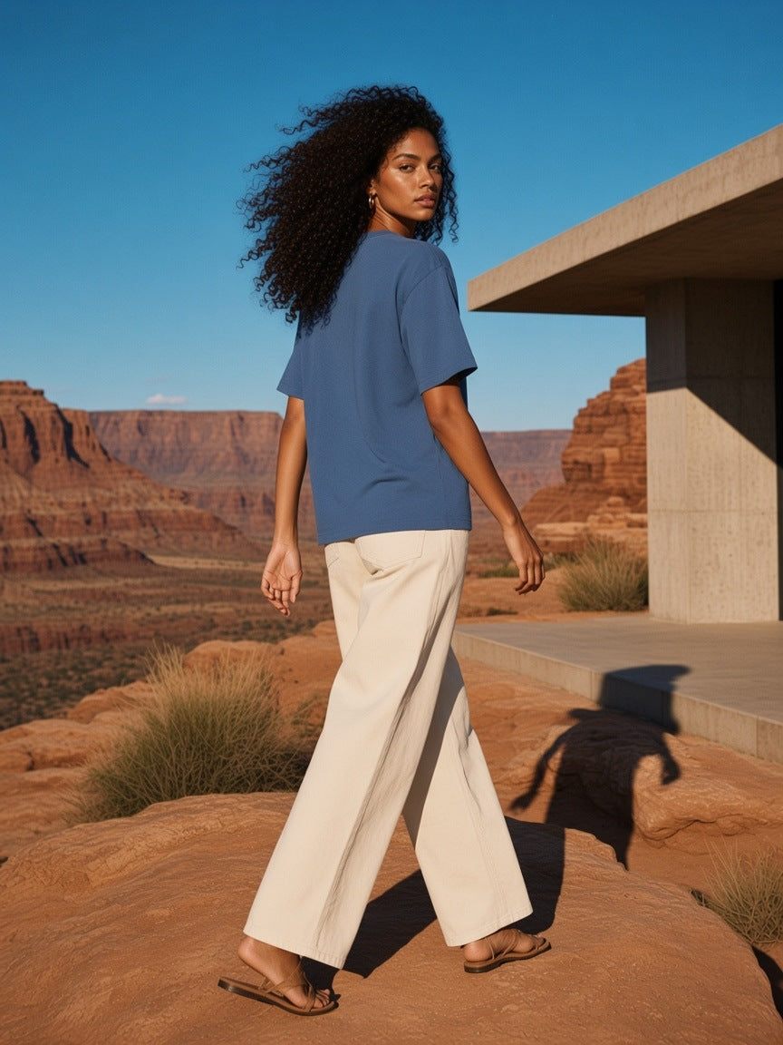 Woman in the Women's Heavyweight Drop Shoulder T-Shirt in Haze Blue standing on sandstone at a desert resort in Utah in the morning