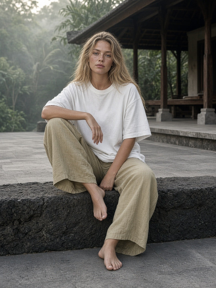 Woman in the Women's Heavyweight Vintage Washed Frayed T-Shirt in White on volcanic stone in Bali at dawn