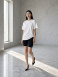 Woman in the Women's Oversized T-Shirt in White in an empty marble hotel lobby at dawn