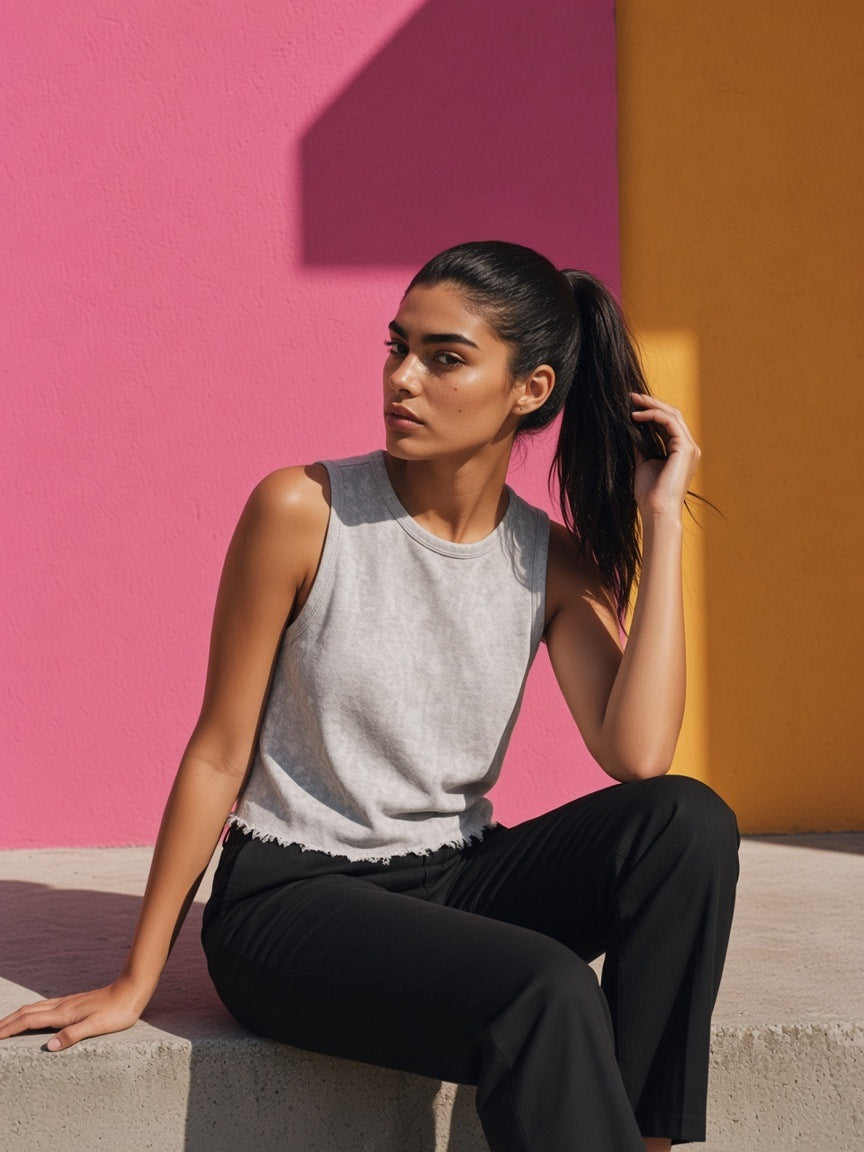 Woman in the Women's Snow Washed Frayed Hem Tank Top in Light Gray against a pink plaster wall in Mexico City in the morning