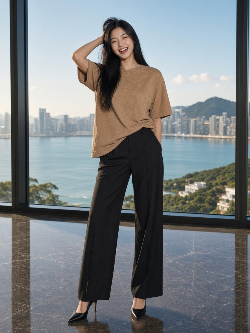 Woman in the Women's Snow Washed Heavyweight Oversize T-Shirt in Camel in a harbour penthouse in Hong Kong by day