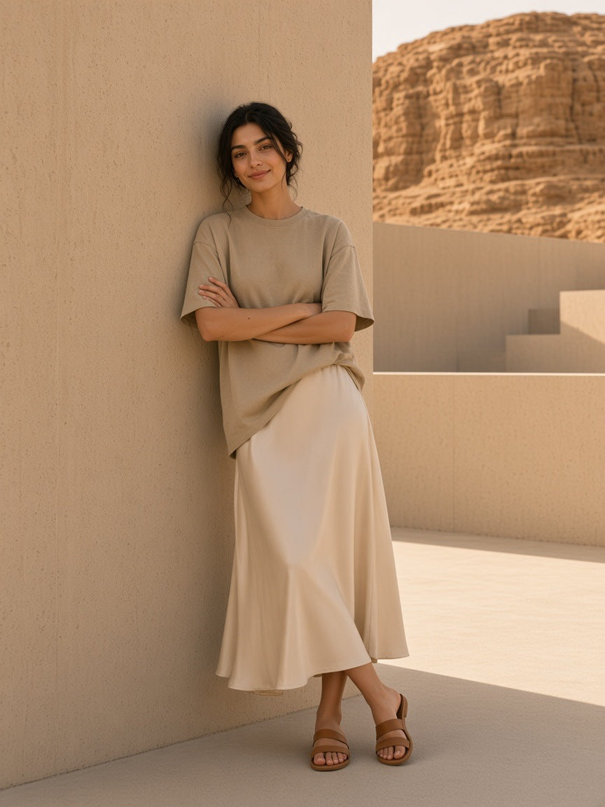 Woman in the Women's Snow Washed Heavyweight Oversize T-Shirt in Khaki in a desert-modern concrete courtyard in Utah at golden hour by day