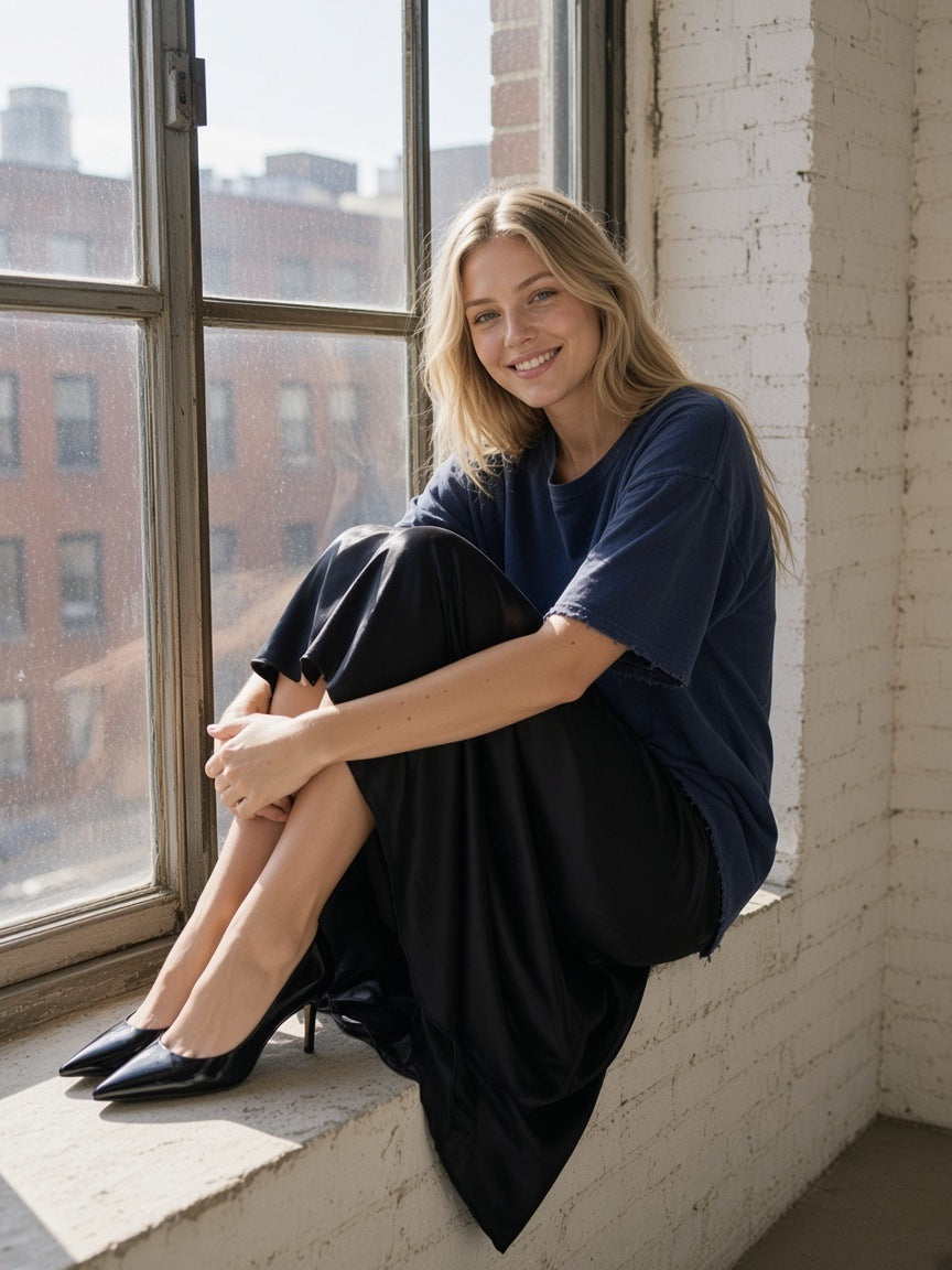 Woman in the Women's Sun Fade Raw Edge T-Shirt in Navy Blue walking through a Tribeca loft in New York in the morning