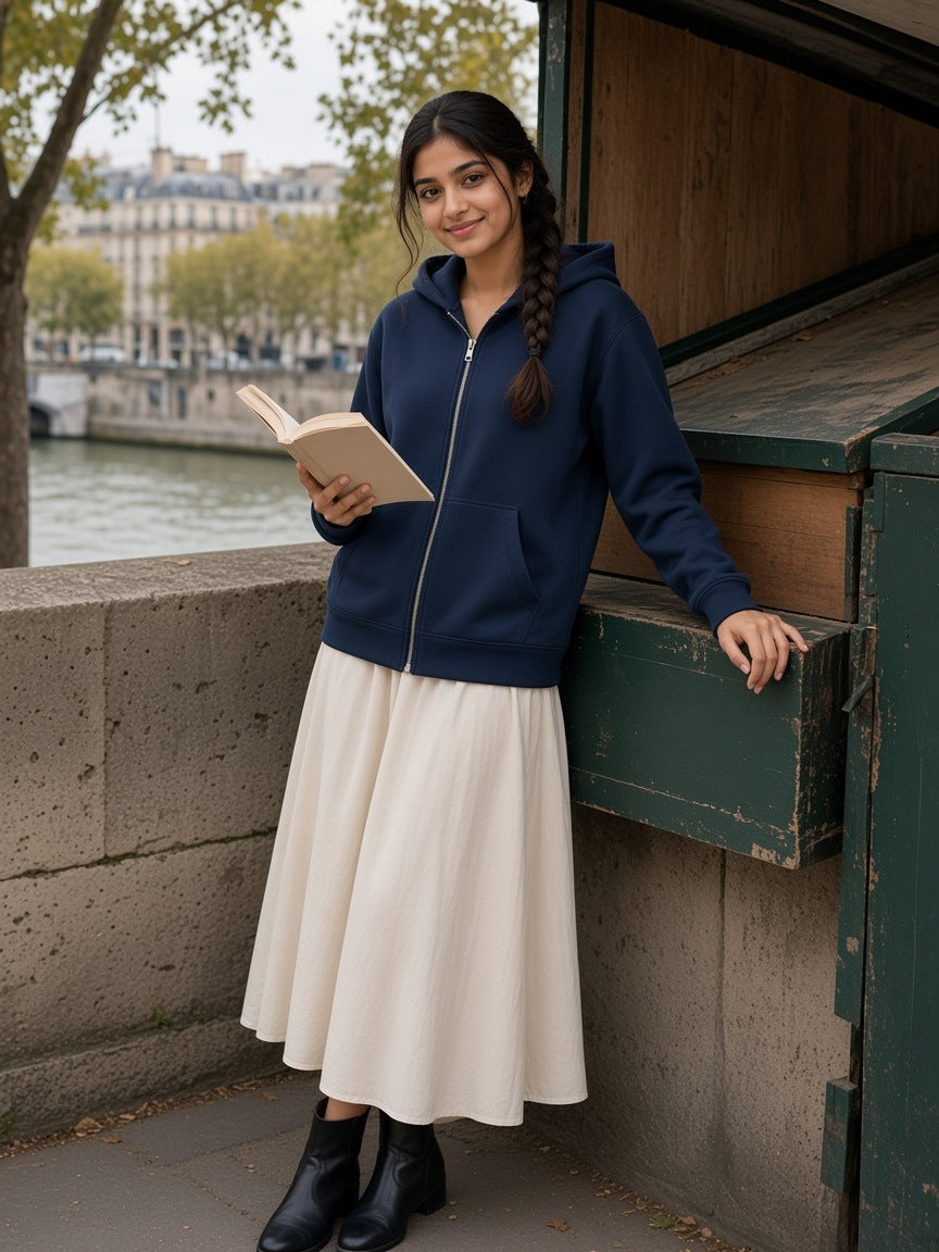 Woman in the Women's Heavyweight Full Zip Hoodie in Navy Blue at a bookstall on the Seine quay